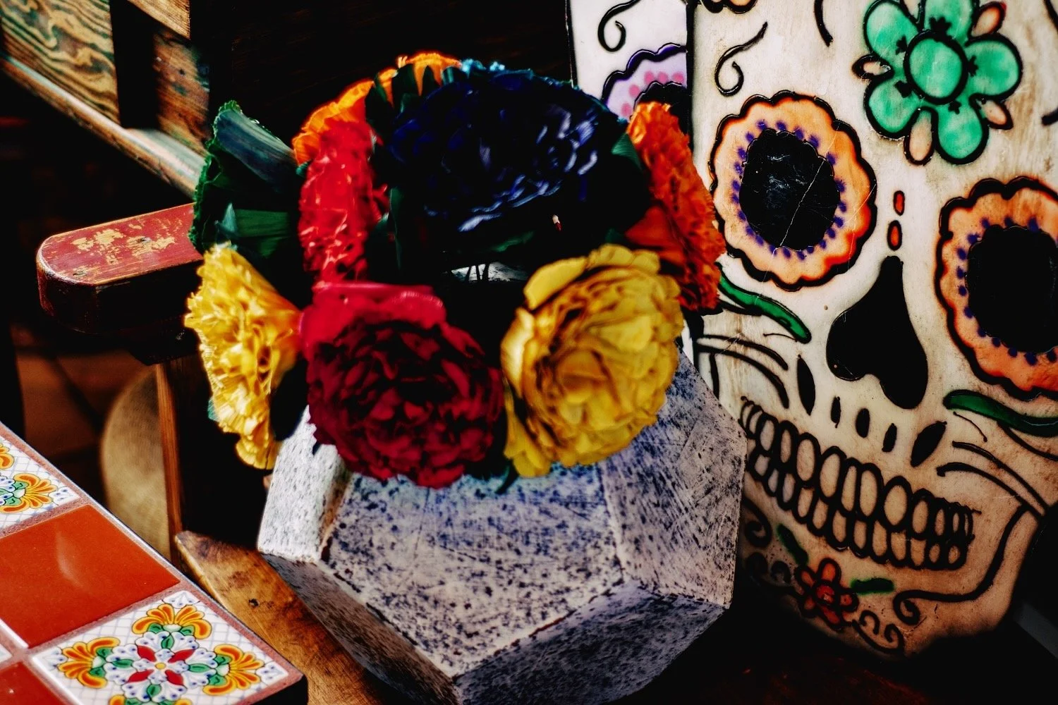 Dia de los Muertos skulls, clay planter with cornhusk flowers. All handmade in Mexico. Shop Milagros Rústicos in Arizona today.