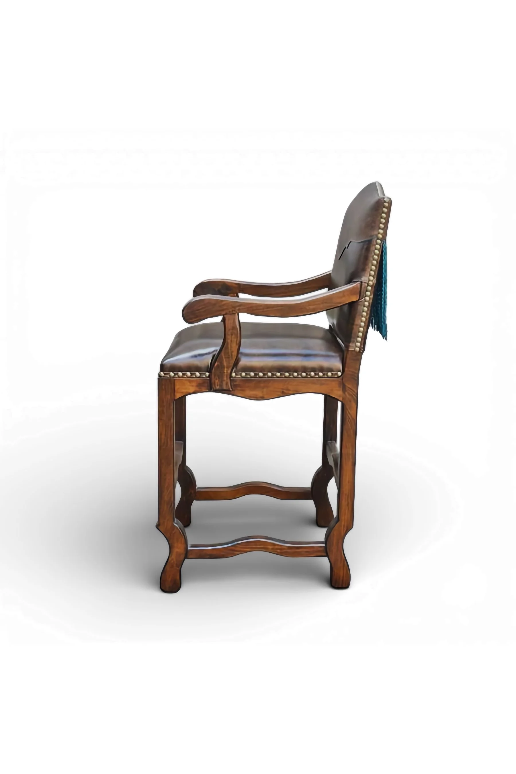 Shop a handmade leather bar stool with turquoise fringe from Mexico. Rustic Southwestern seating with carved wood and bold artisan detail.