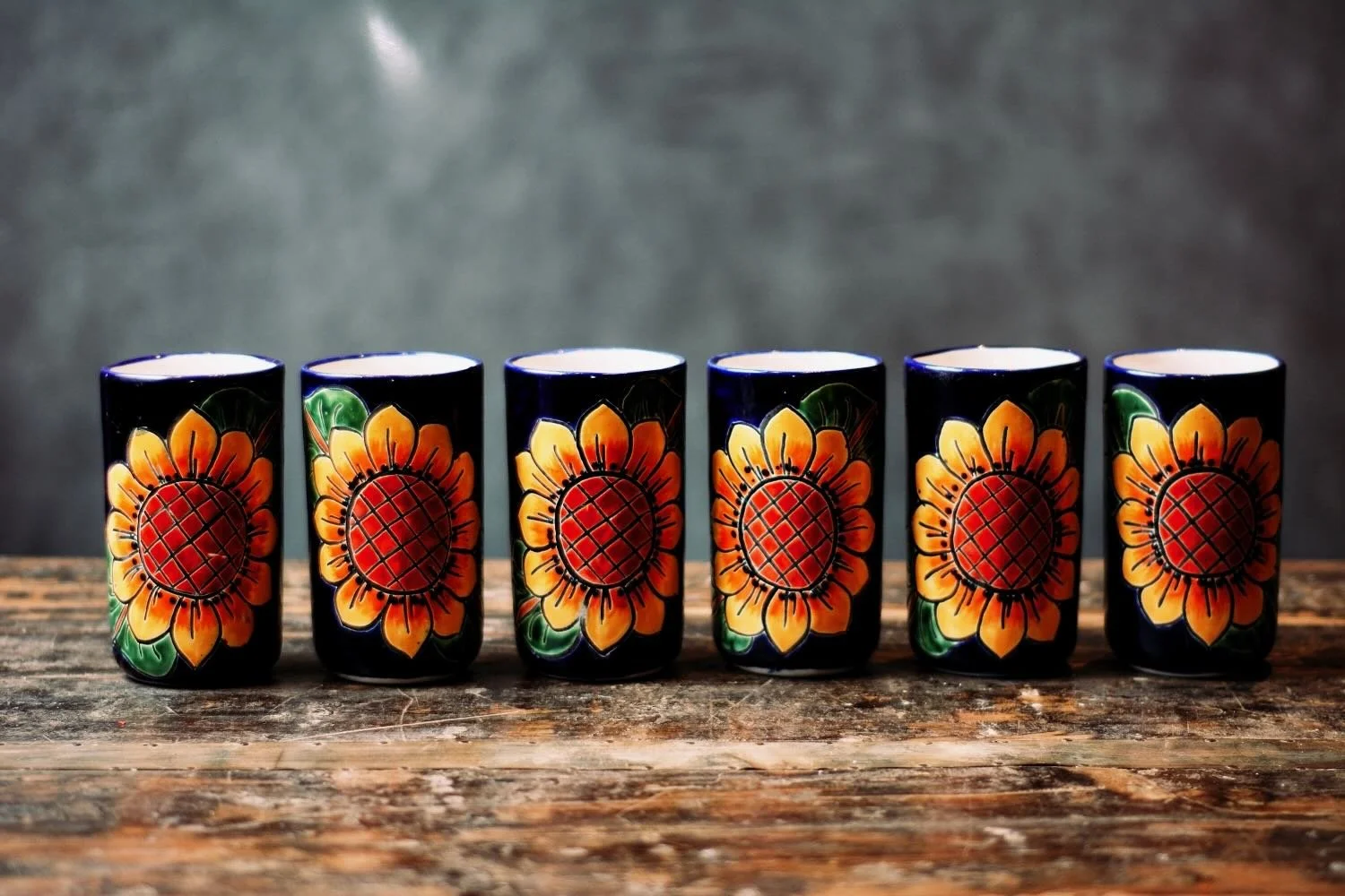 Talavera Sunflower Pitcher & Cup Set. Hand-painted Talavera set featuring a cobalt blue pitcher and matching cups with a vibrant sunflower design.