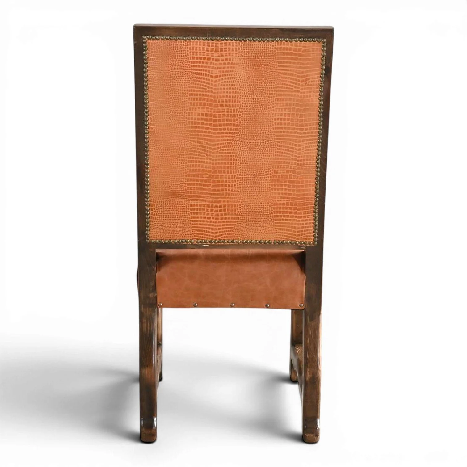 Handmade San Lucas terracotta leather dining chair with embossed leather back, nailhead trim, and dark wood frame crafted in Mexico.