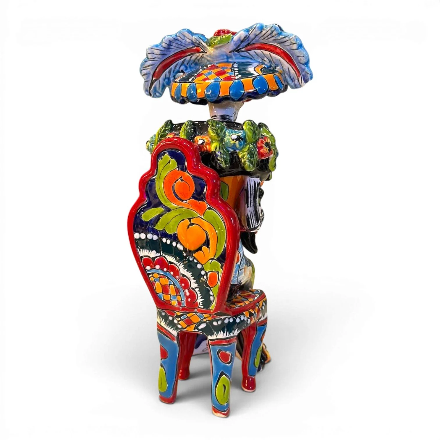 Handmade Mexican Catrina folk art figure seated in a chair holding a fan