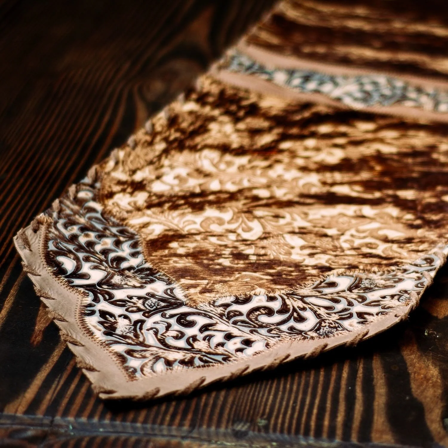 Handmade Brazilian cowhide table runner with tooled leather.