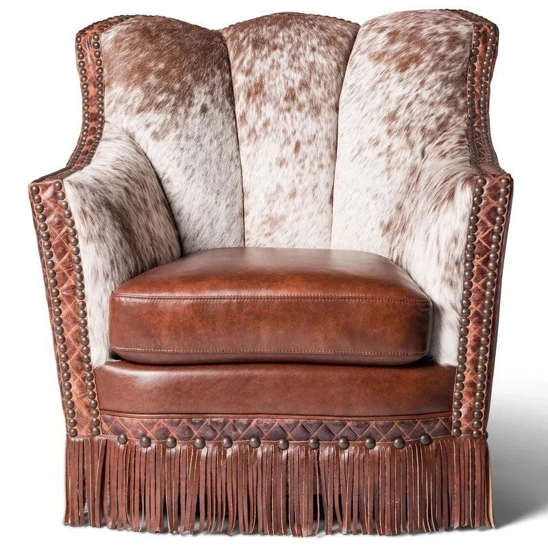 The Arvada Cowhide Fringe Swivel Chair features premium top-grain leather, cowhide accents, fringe detailing, and smooth swivel functionality for refined Western comfort.
