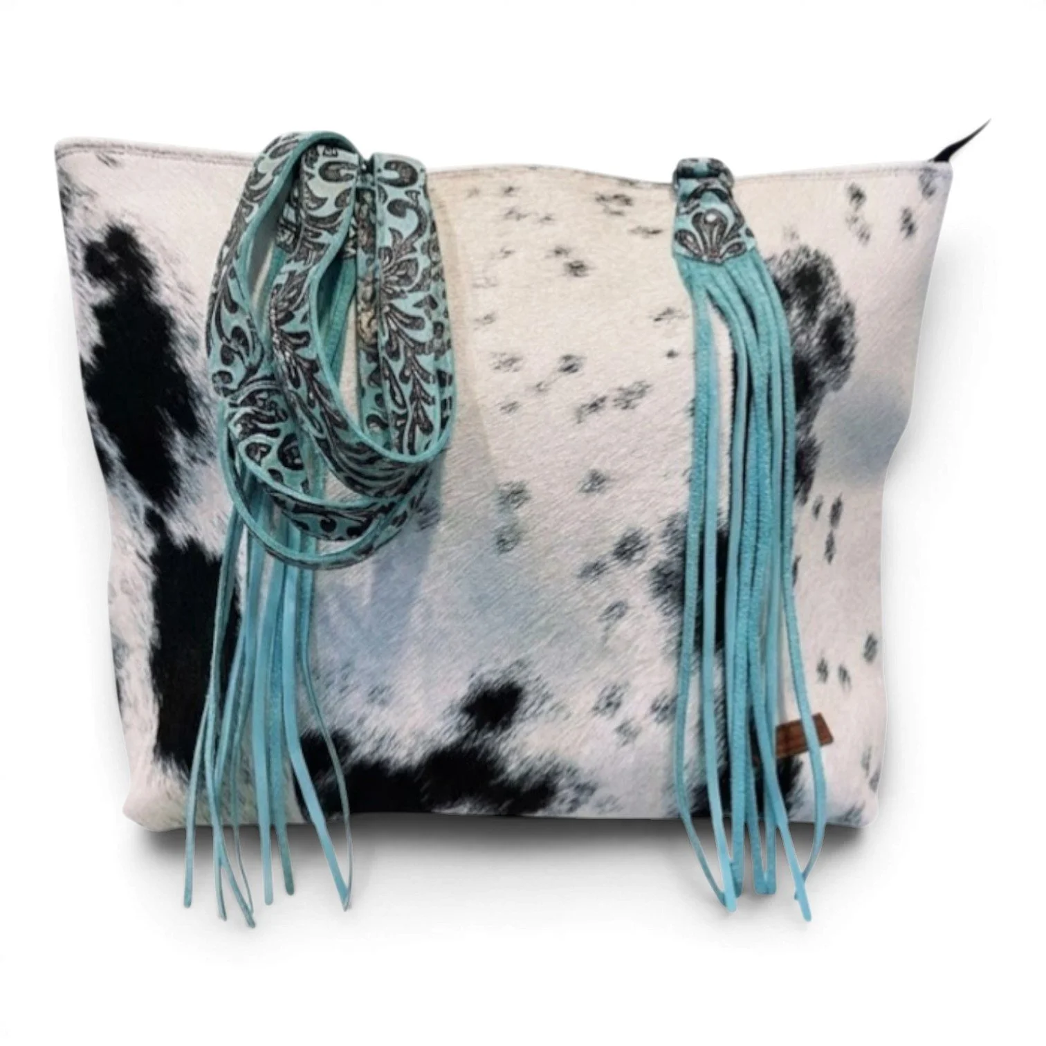 Handmade Brazilian Sheridan cowhide tote bag with black and white hide, black leather back, and turquoise fringe strap