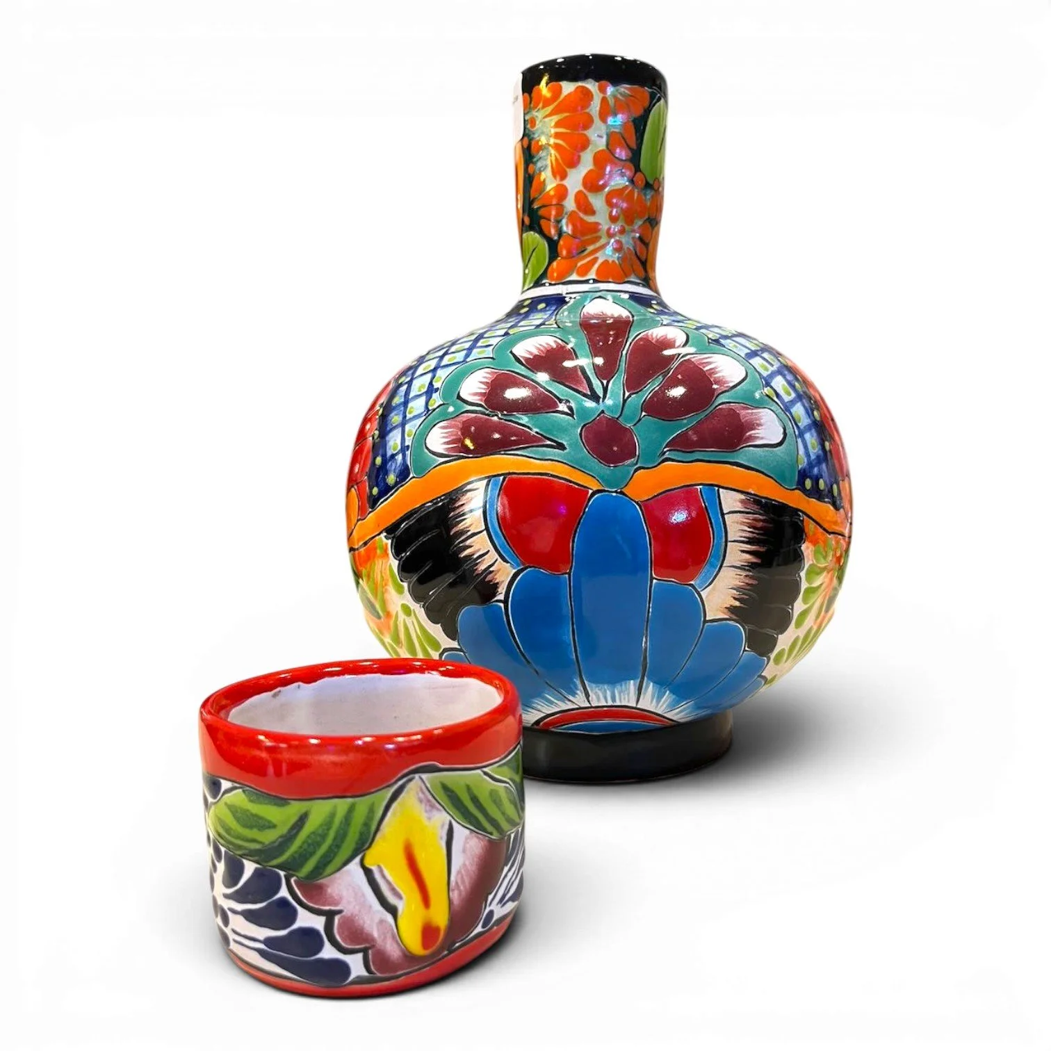 Handmade Mexican Talavera tequila bottle with matching cup featuring vibrant hand-painted ceramic design.