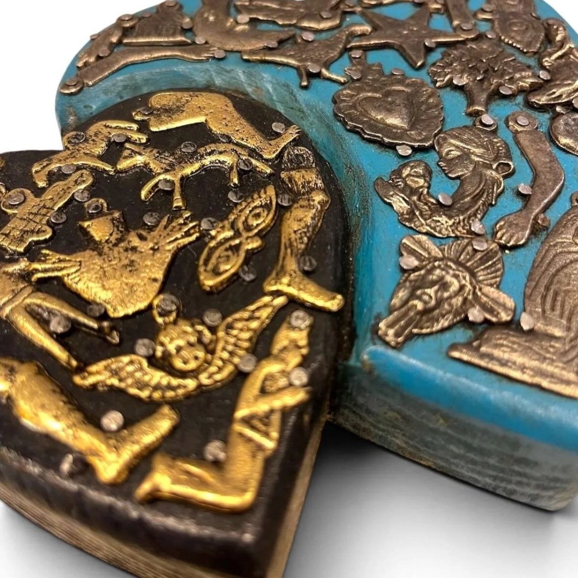 Handmade Mexican double heart wall décor with blue and black hand-painted hearts accented by traditional silver Milagros charms.