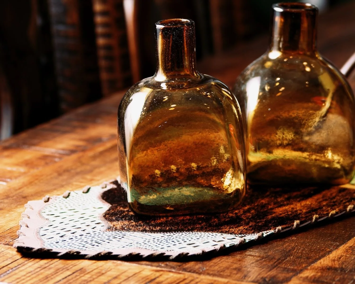 Handblown glass tequila bottle and cowhide and leather table runner.