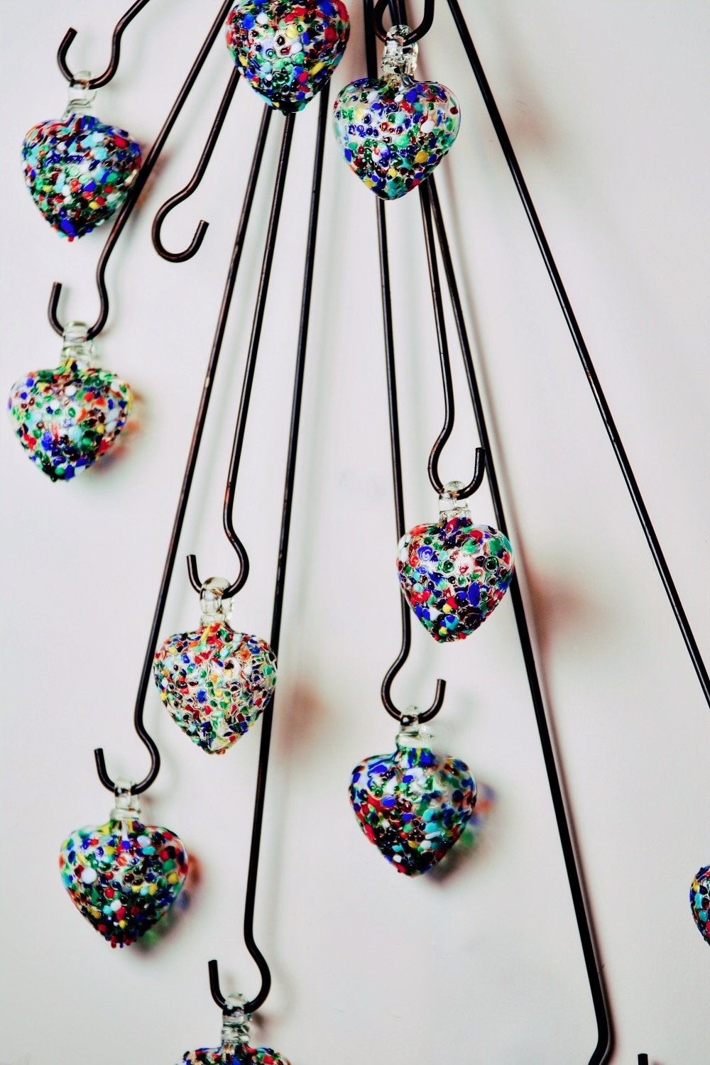 Handblown confetti glass hearts and iron hanger from Mexico.