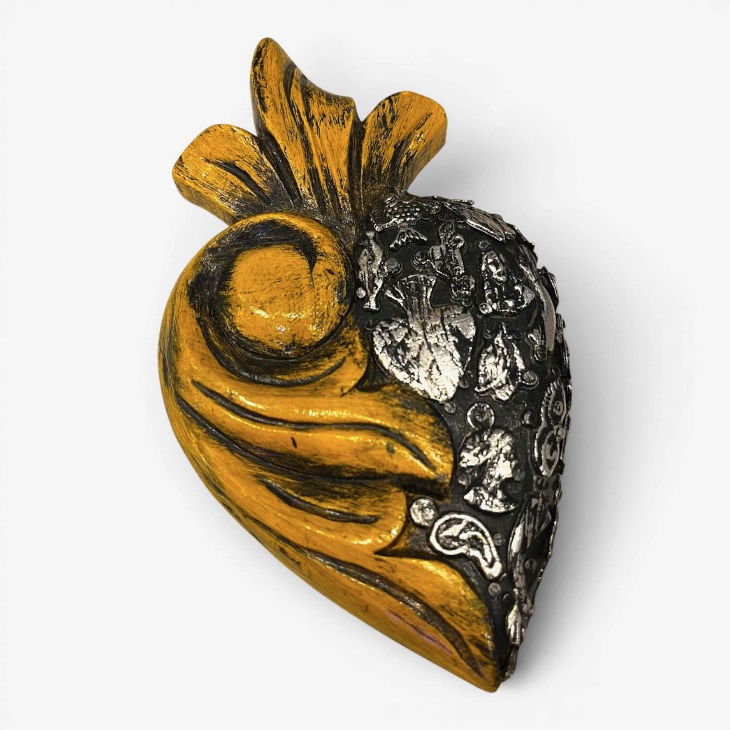 Handmade Mexican yellow Milagros heart wall décor with a carved swirl design and traditional silver milagros charms.