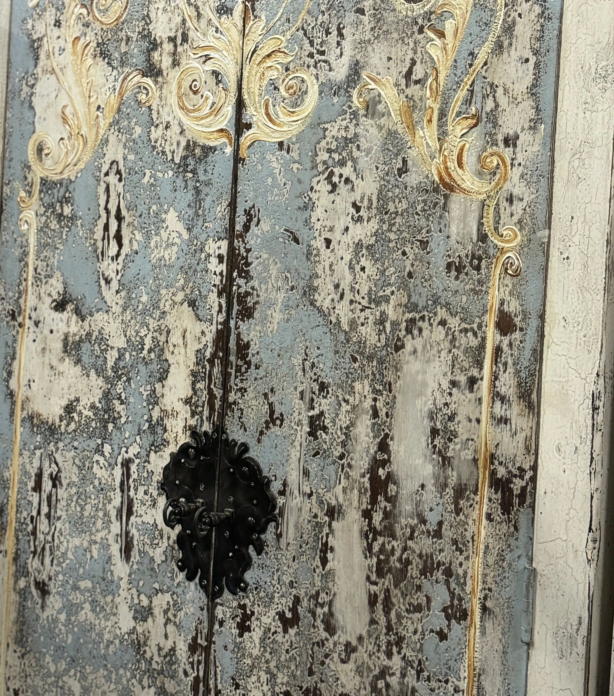 Mirador handmade Peruvian armoire with waxed white finish, hand-painted blue panel, cream and gold scrollwork, distressed antique finish, and hand-forged iron handle.