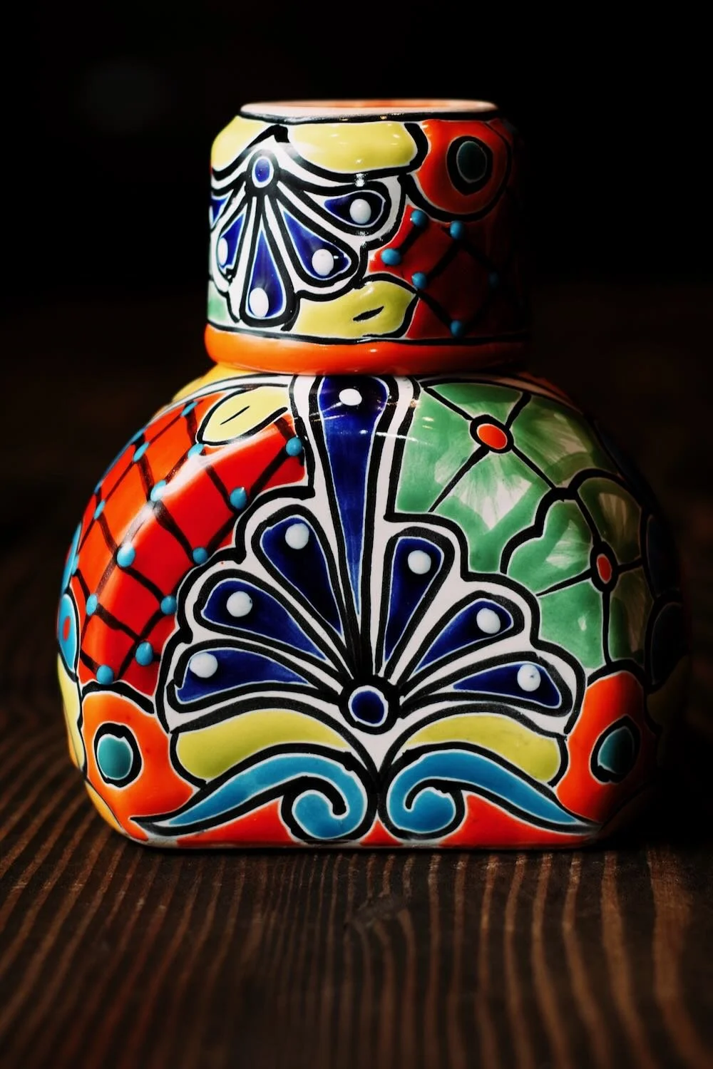 Shop a handmade Talavera tequila bottle with cup lid from Mexico. Colorful, lead-free artisan barware perfect for serving and display.