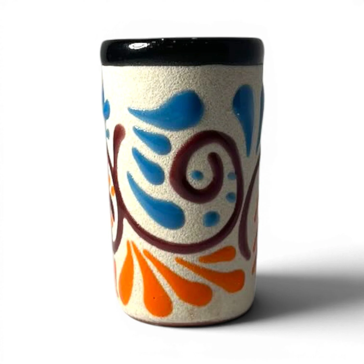 Handmade Mexican stone tequila shot cups with vibrant Talavera design and glazed interior.