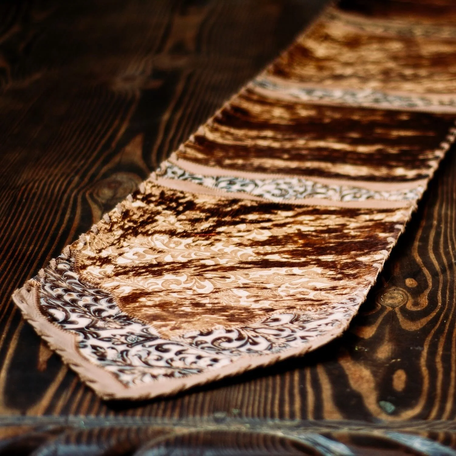 Handmade Brazilian cowhide table runner with tooled leather.