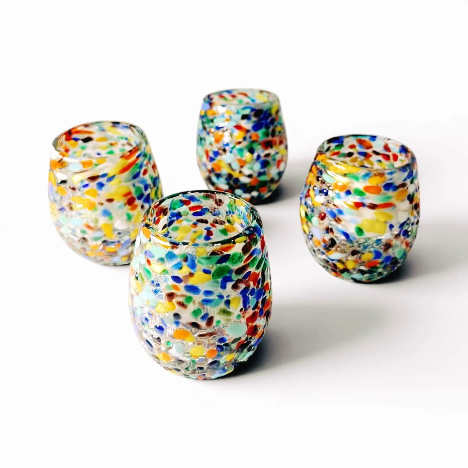 Set of four handmade Mexican Guanajuato confetti shot glasses with colorful textured artisan finish.