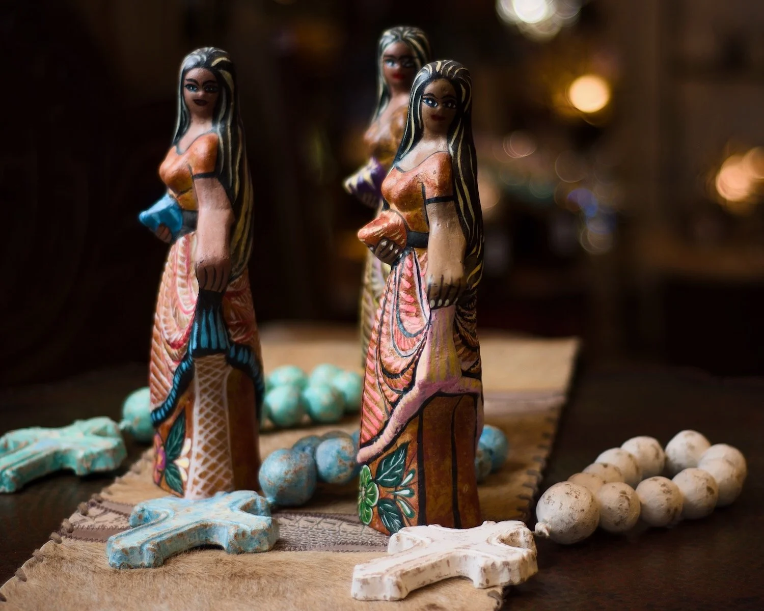 Three clay ladies with a flowing dresses and clay rosary beads from Mexico. Beautiful table art.