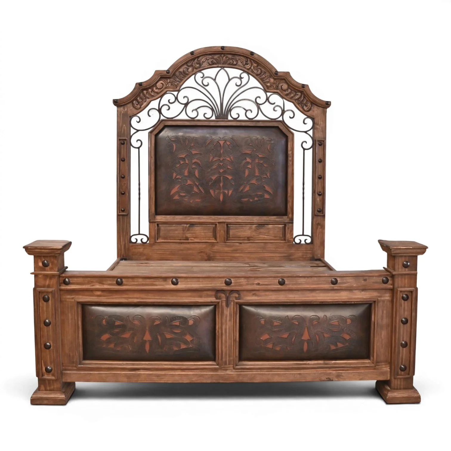 Handmade Hacienda Hierro tooled leather bed with arched headboard, decorative ironwork, hand-carved wood, and rustic clavos accents.
