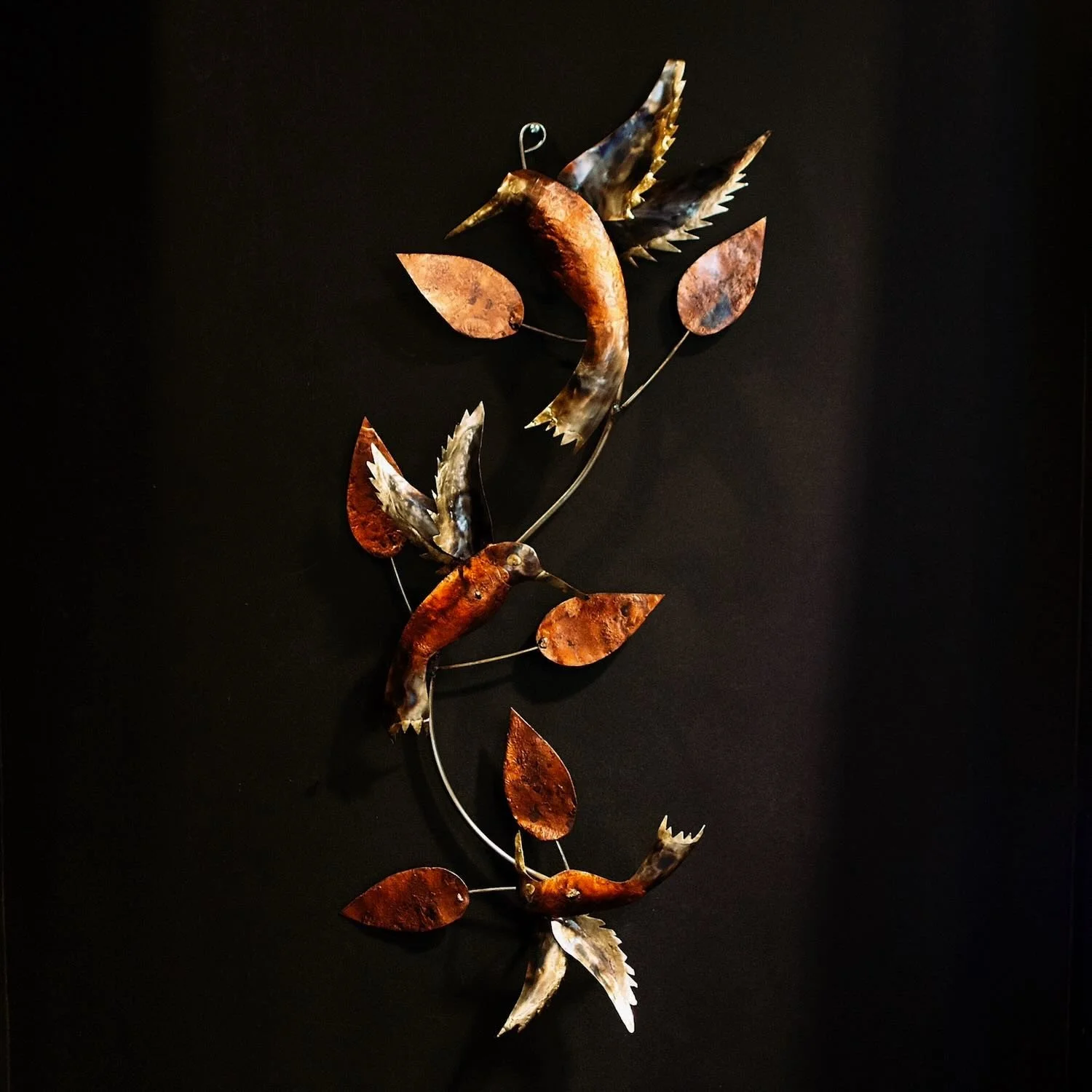 Handmade Colibrí de Cobre wall art featuring three copper hummingbirds crafted in Mexico.