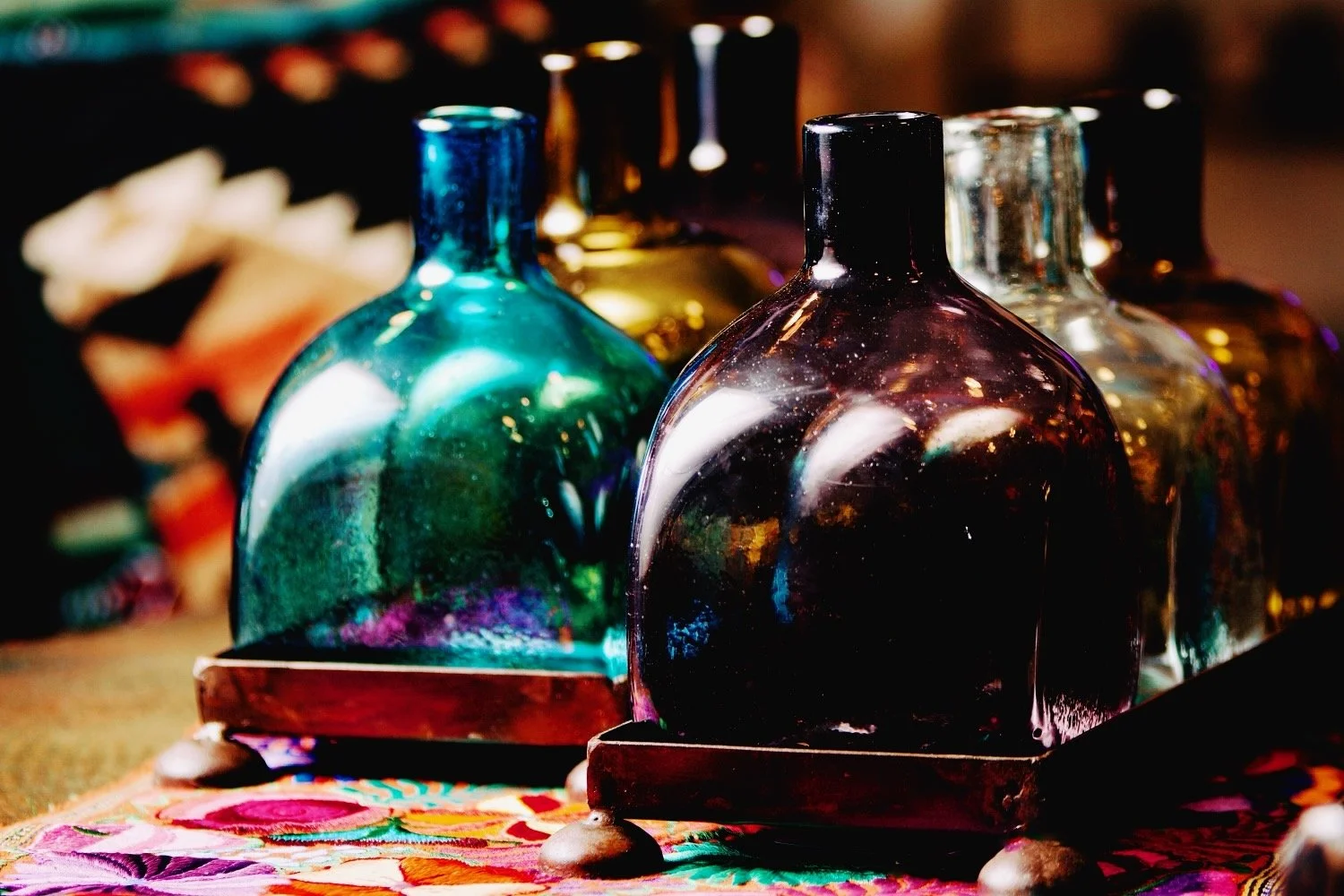 Handmade Mexican serving set featuring three handblown glass bottles and a handcrafted iron tray, perfect for entertaining and rustic décor.
