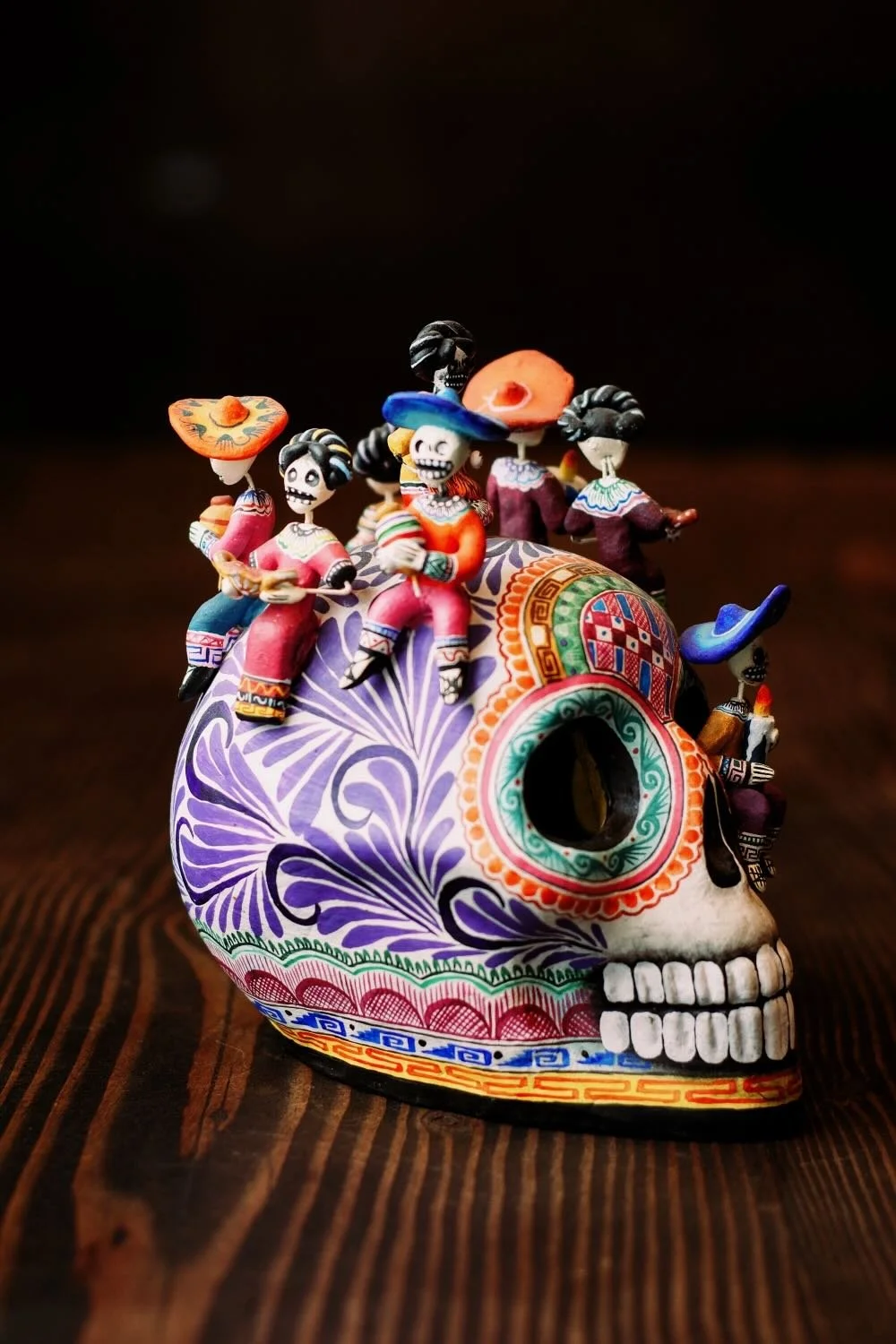 Shop a handmade Montesinos skull with Catrinas from Mexico. Colorful clay folk art with intricate detail, perfect for unique decor displays.