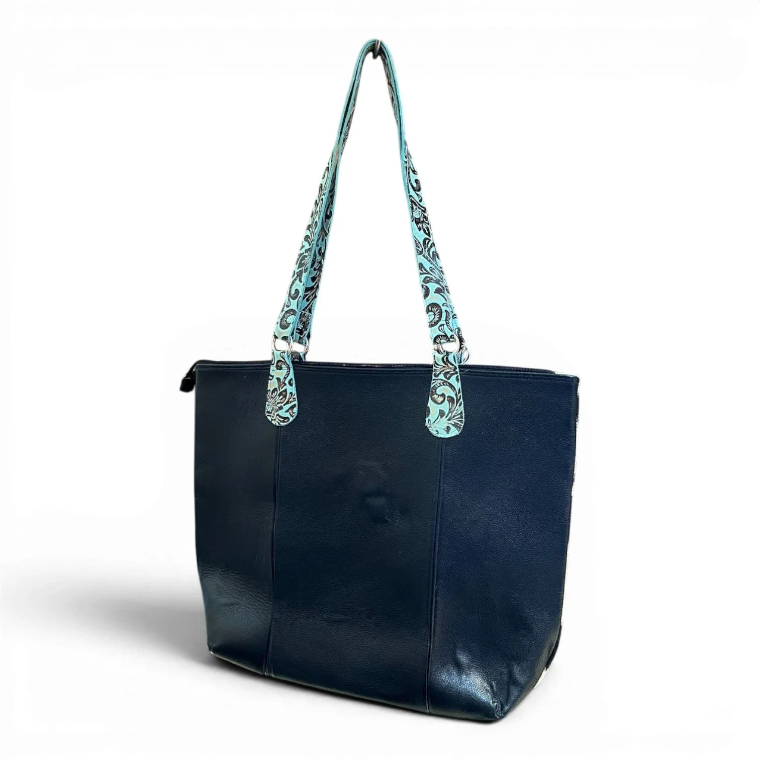 Handmade Brazilian Sheridan cowhide tote bag with black and white cowhide, black leather back, and turquoise fringe