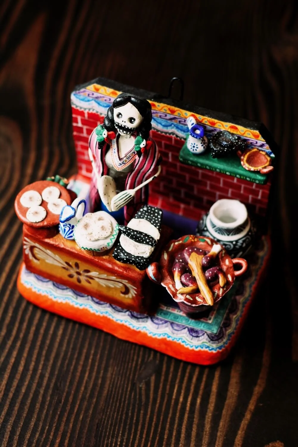 Shop a handmade Catrina kitchen scene from Mexico. Colorful clay folk art featuring a tortilla-making Catrina, perfect for unique decor displays.