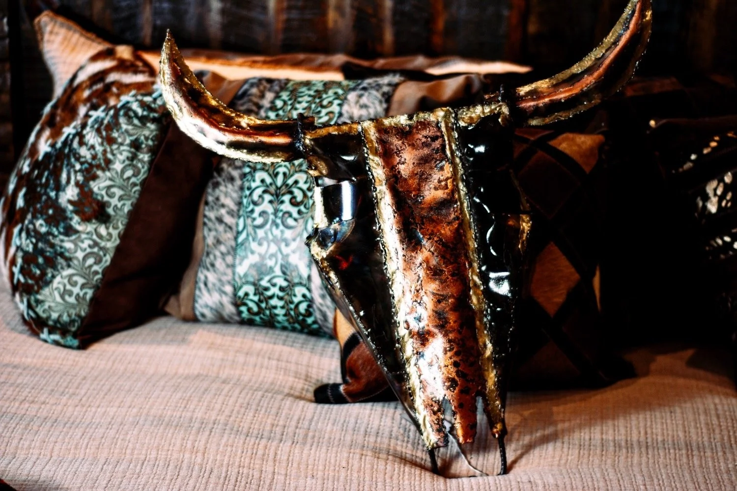 Handmade copper steer skull, tooled leather and cowhide pillows on a rustic Hacienda style bed from Mexico - Milagros Rústicos
