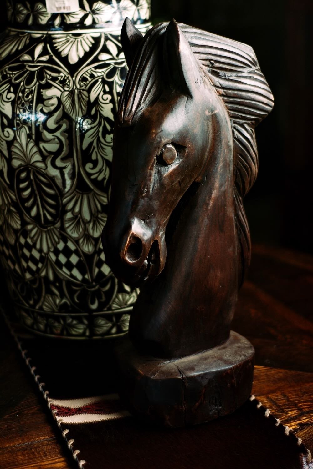 Hand carved horse head with black and white Talavera ginger jar from Mexico.