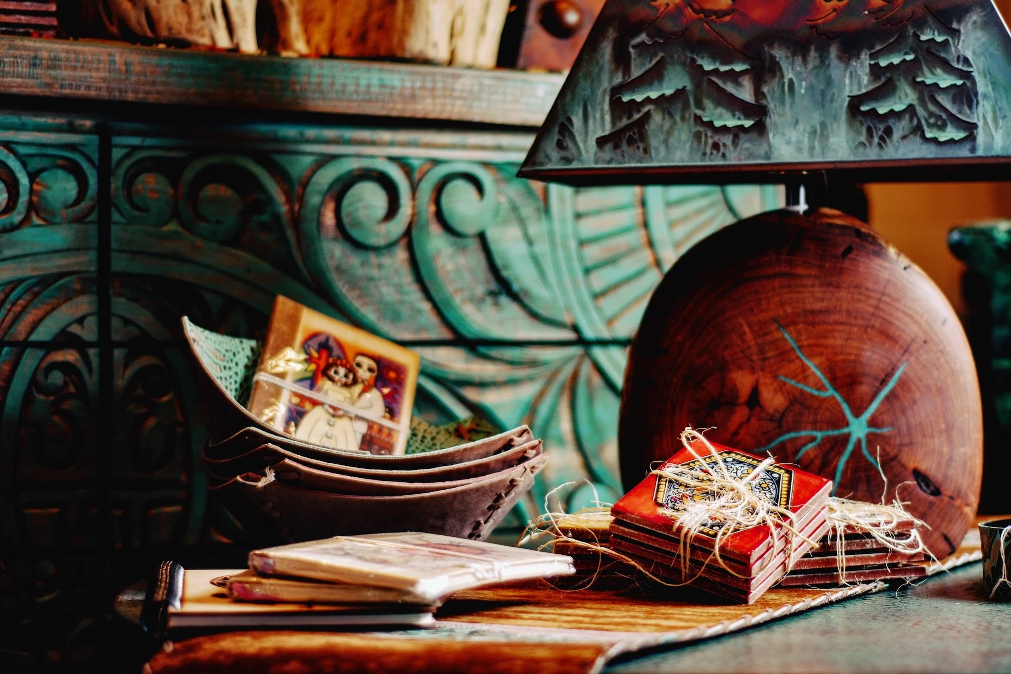 Hand carved turquoise dresser, mesquite lamp with copper shade, Talavera tile coasters & miscellaneous decor from Mexico.