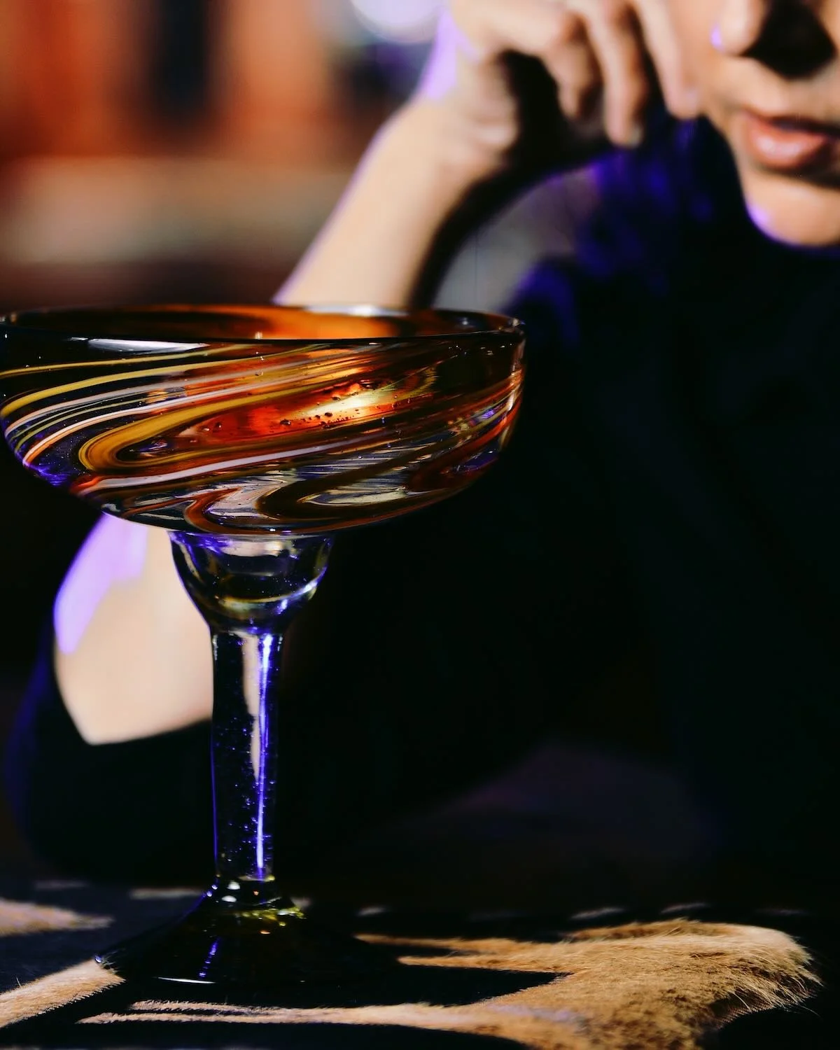 Girl drinking margaritas in a colorful handblown margarita glass.