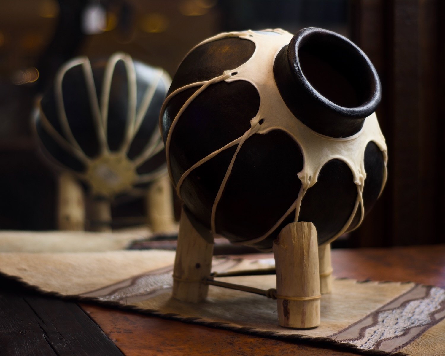 Tarahumara pottery, Brazilian cowhide table runner on a hand pounded copper coffee table reflecting in a mirror. 