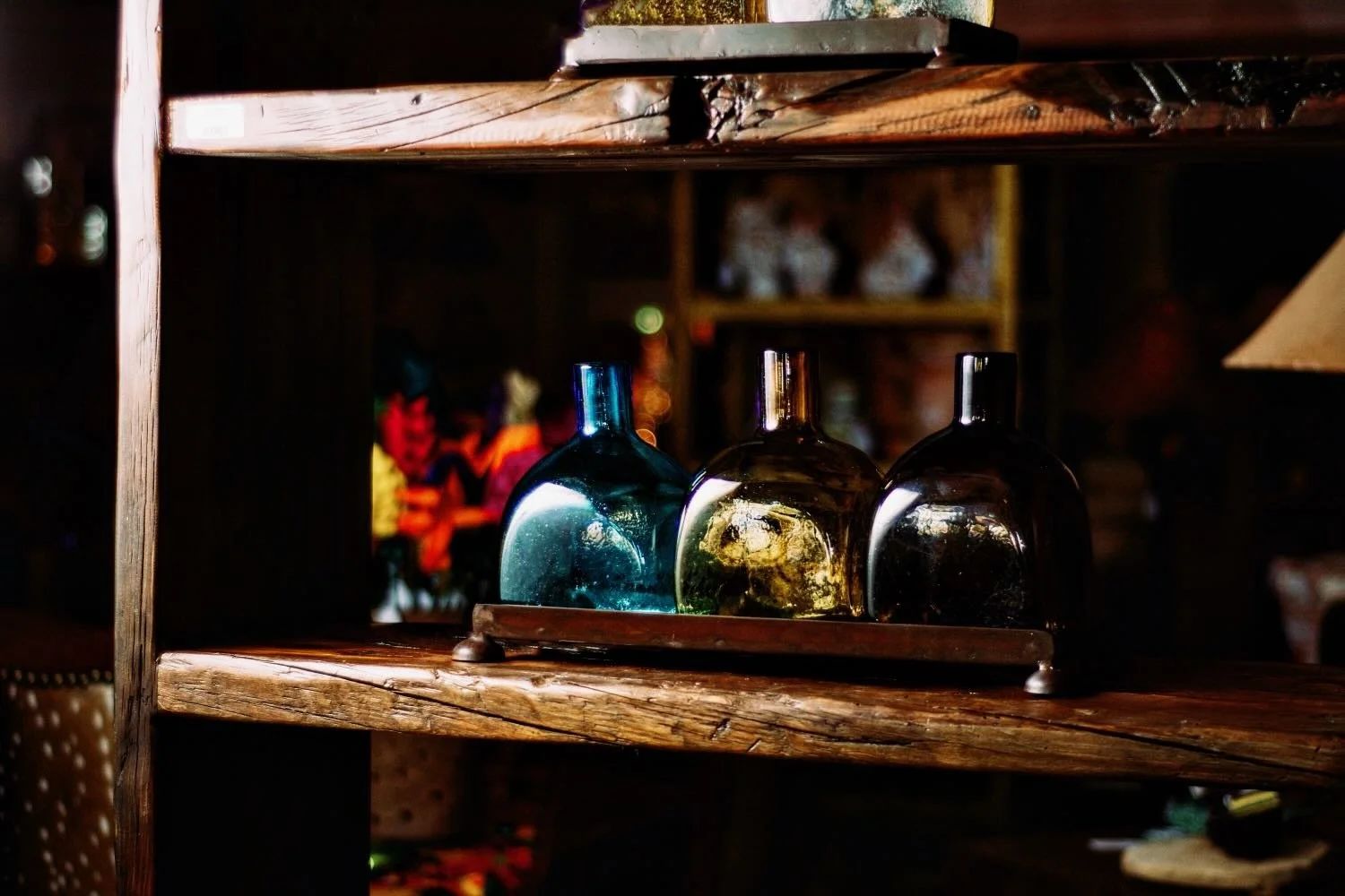 Handmade Mexican serving set featuring three handblown glass bottles and a handcrafted iron tray, perfect for entertaining and rustic décor.