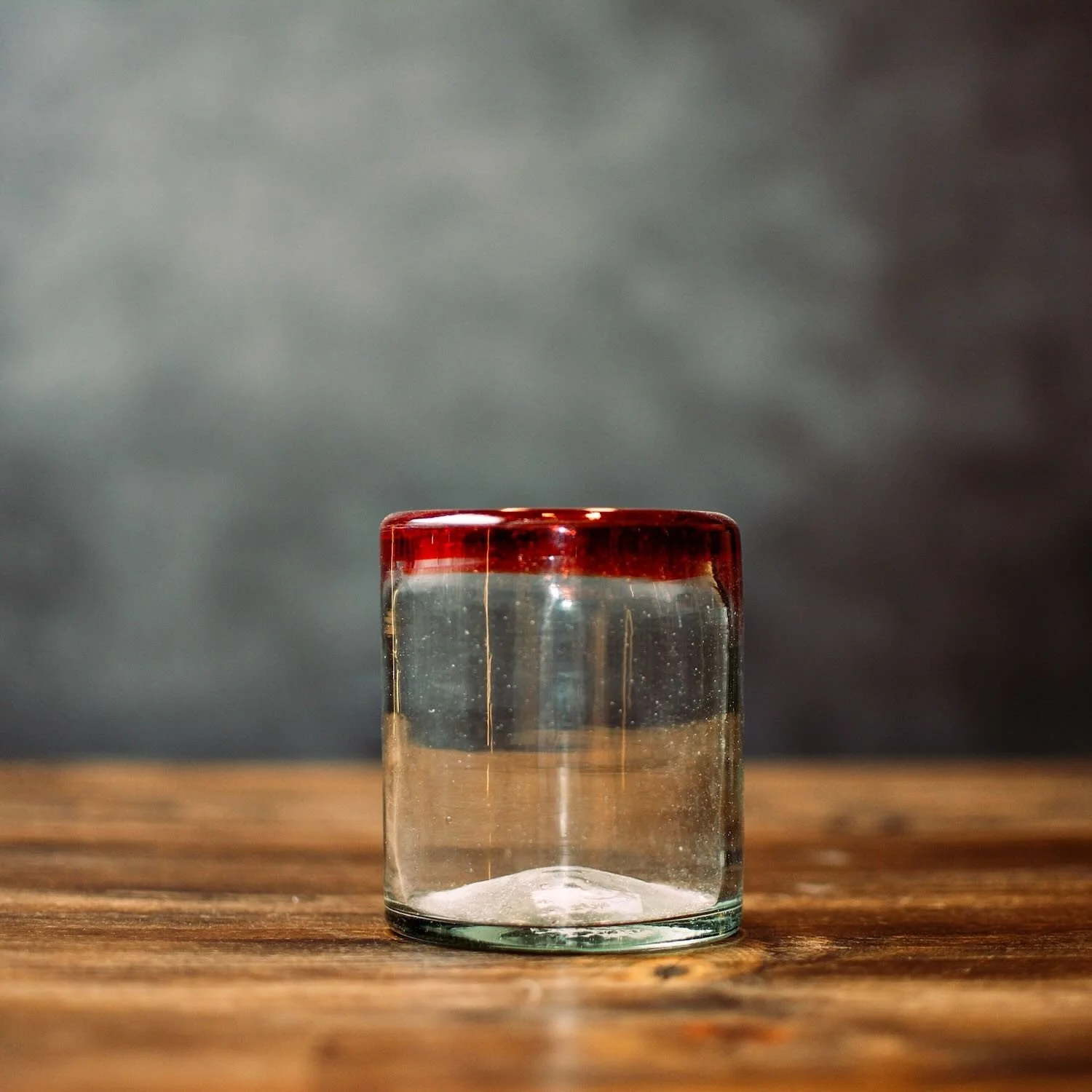 Handmade Mexican Cantina short glass with traditional red rim and handblown artisan craftsmanship.