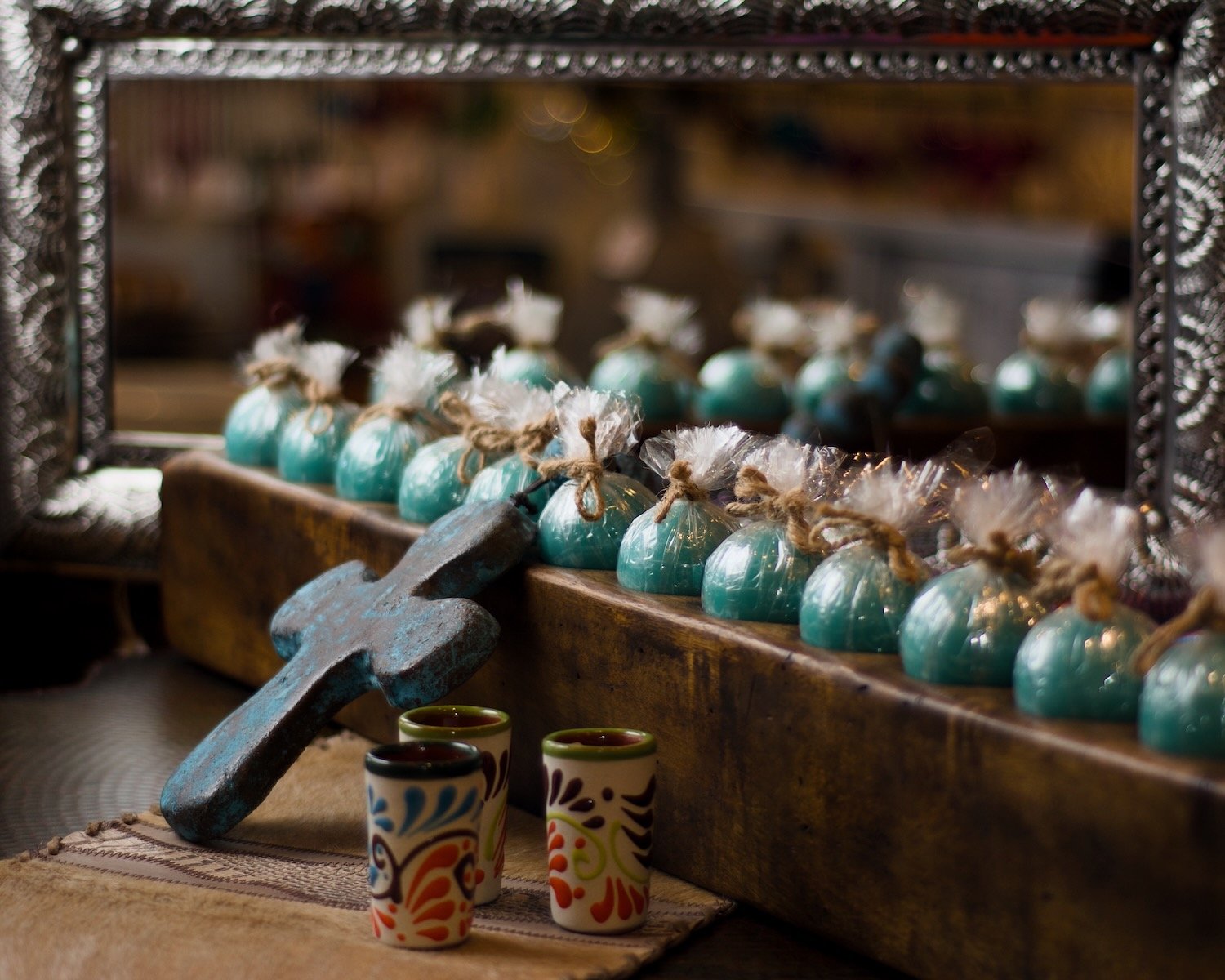 Vintage sugar molds with round tuquoise & cream candles, stone shot cups, blue clay rosary and silver punched tin mirror from Mexico