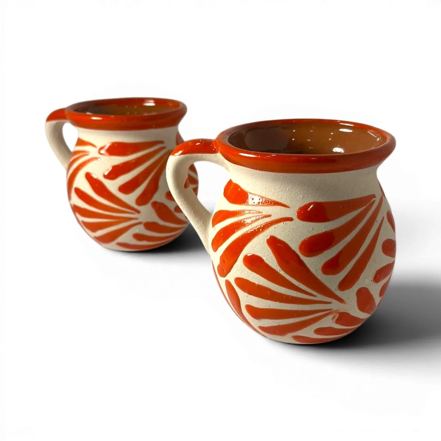 Handmade Mexican orange clay mug set with glazed rims and artisan interior and exterior design.