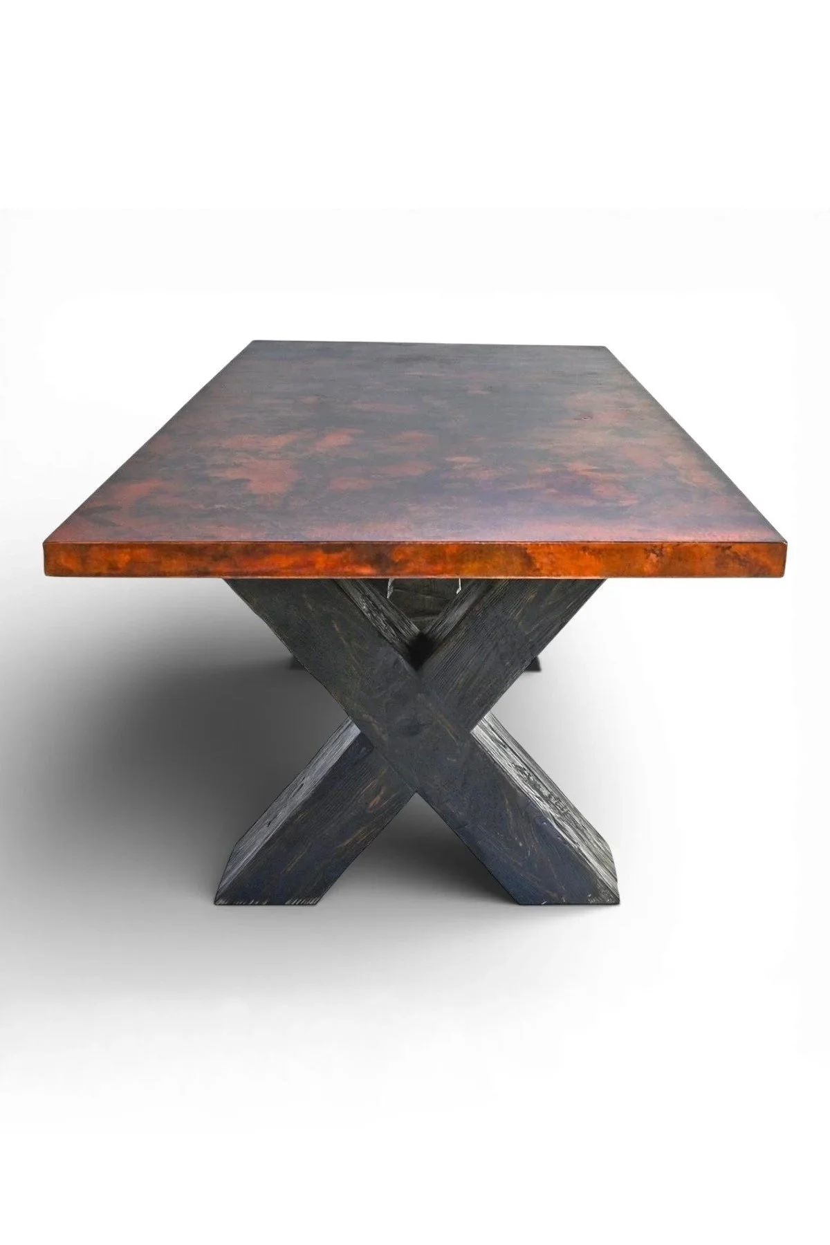 Shop a large handmade copper dining table from Mexico. Live edge copper top with wood base, perfect for rustic luxury dining and gatherings.
