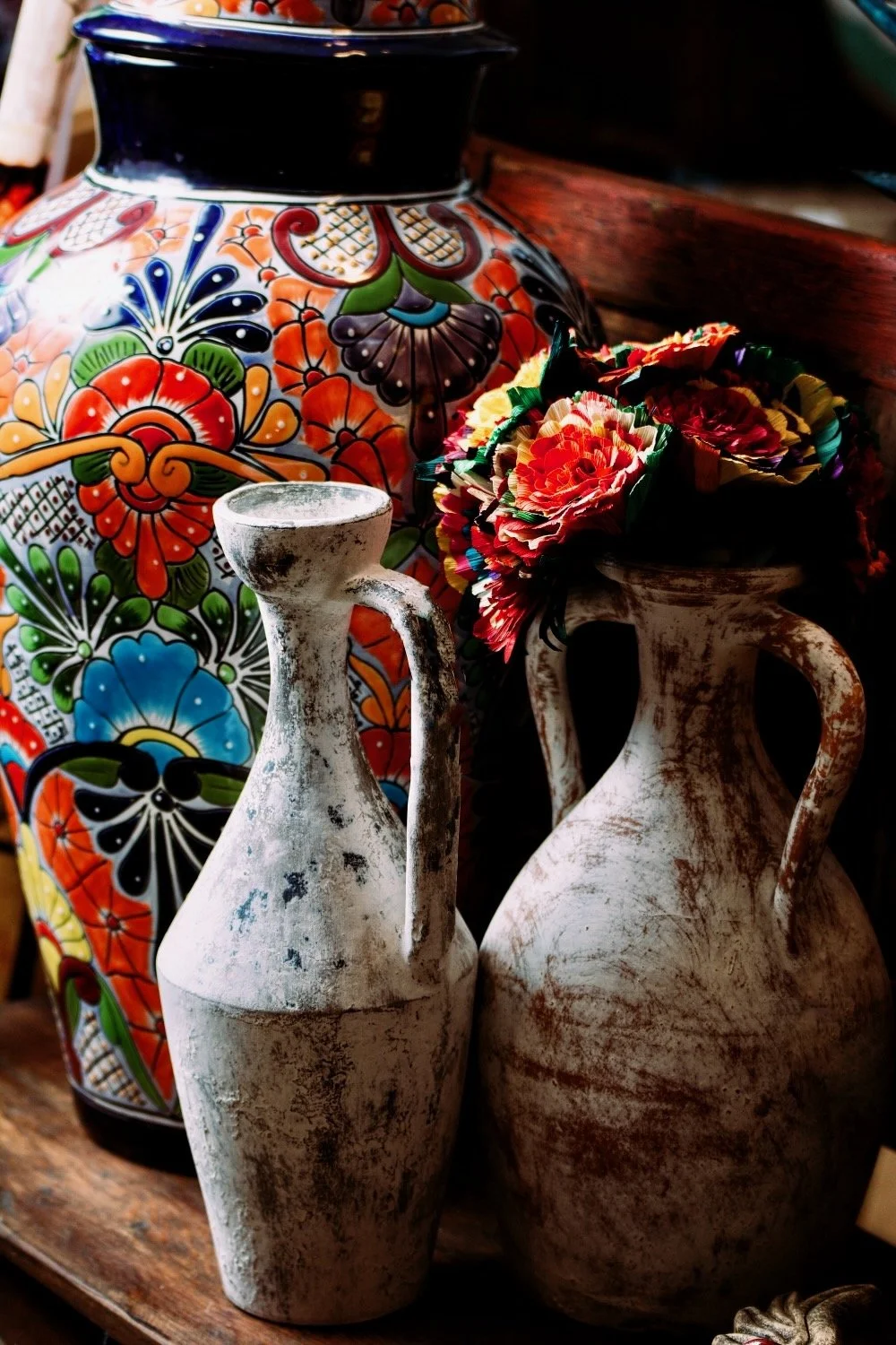 Handmade distressed white clay vases with cornhusk flowers and Talavera ginger jar from Mexico.