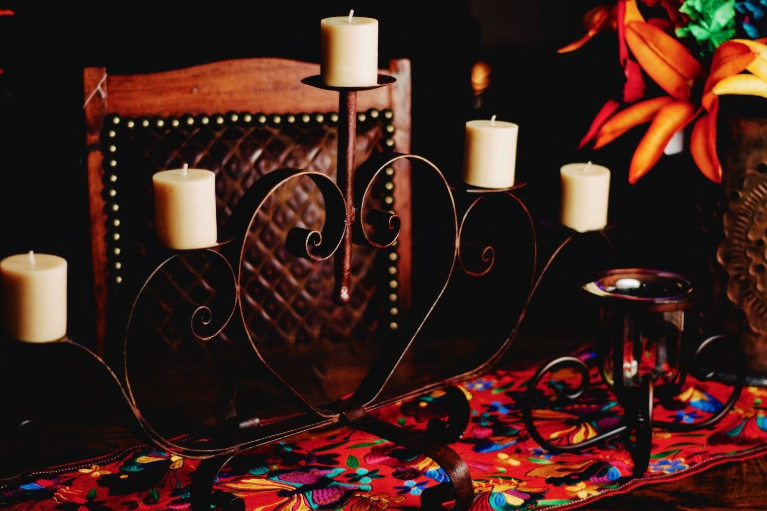 Iron heart shaped candelabra, embroidered runner and leather dining chairs from Mexico.