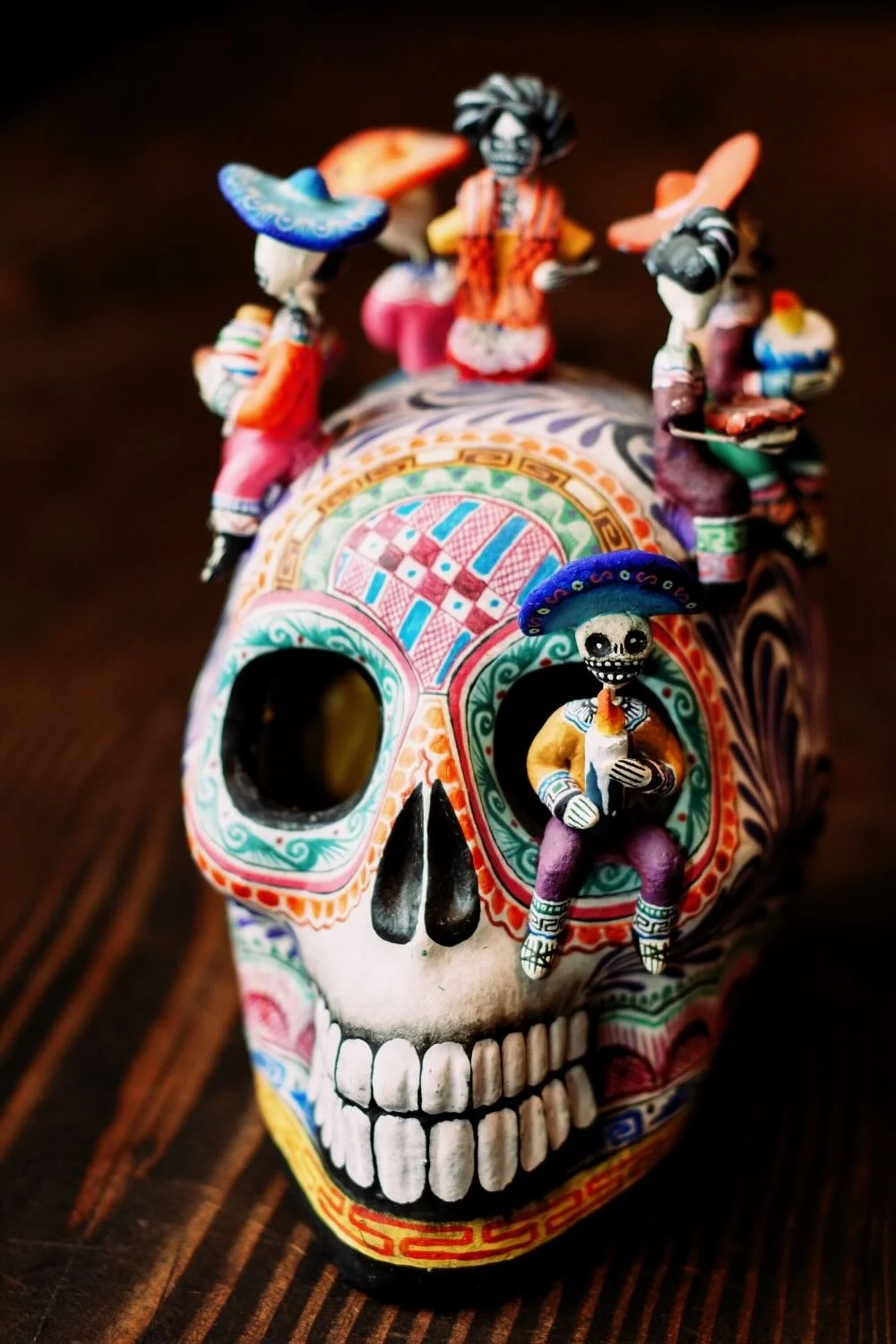 Shop a handmade Montesinos skull with Catrinas from Mexico. Colorful clay folk art with intricate detail, perfect for unique decor displays.