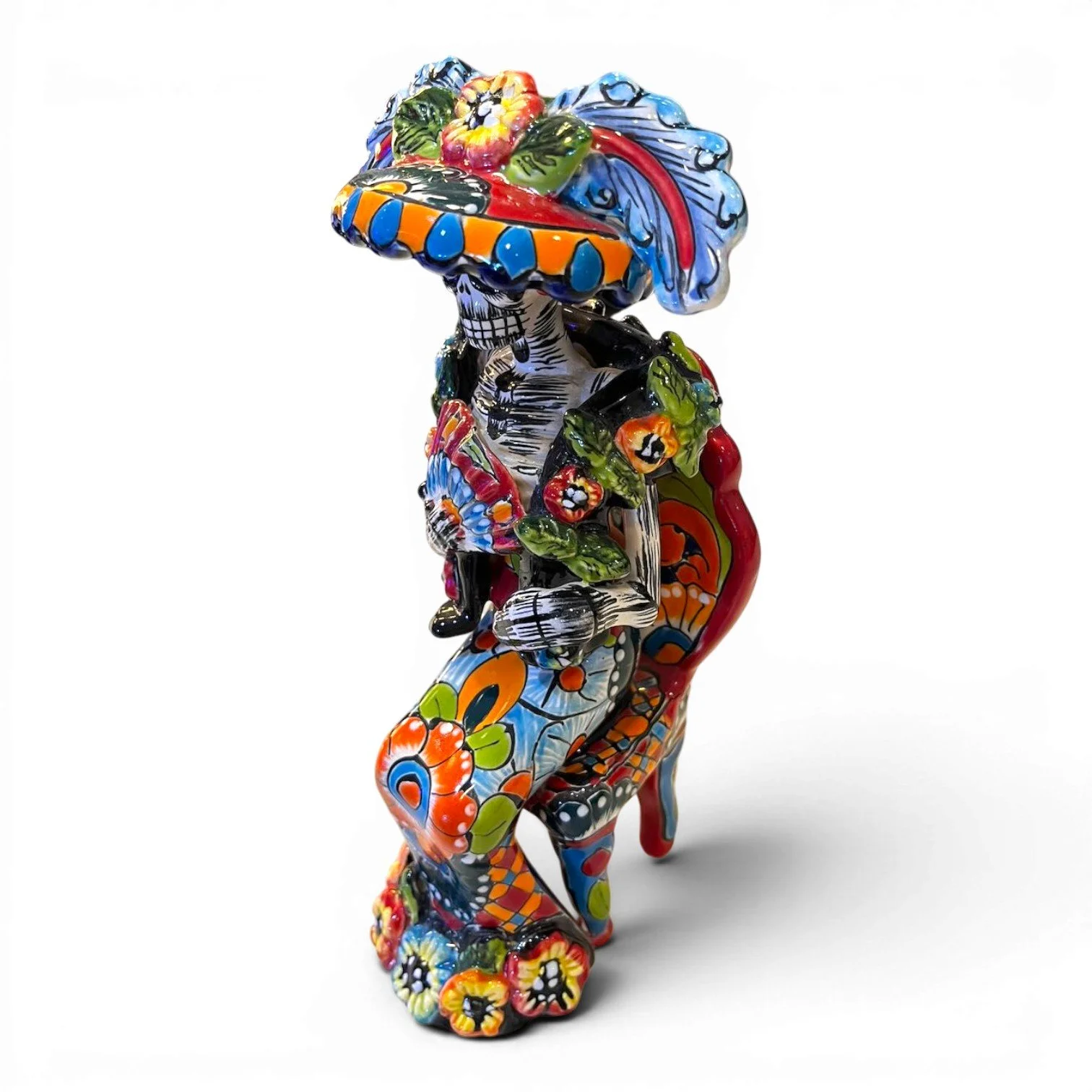 Handmade Mexican Catrina folk art figure seated in a chair holding a fan