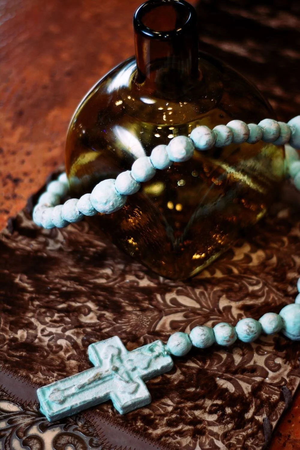 Rosario de Barro - Turquesa. Handcrafted 27" turquoise clay rosary from Milagros Rústicos. Features a distressed finish. Ideal for home altars or rustic decor.