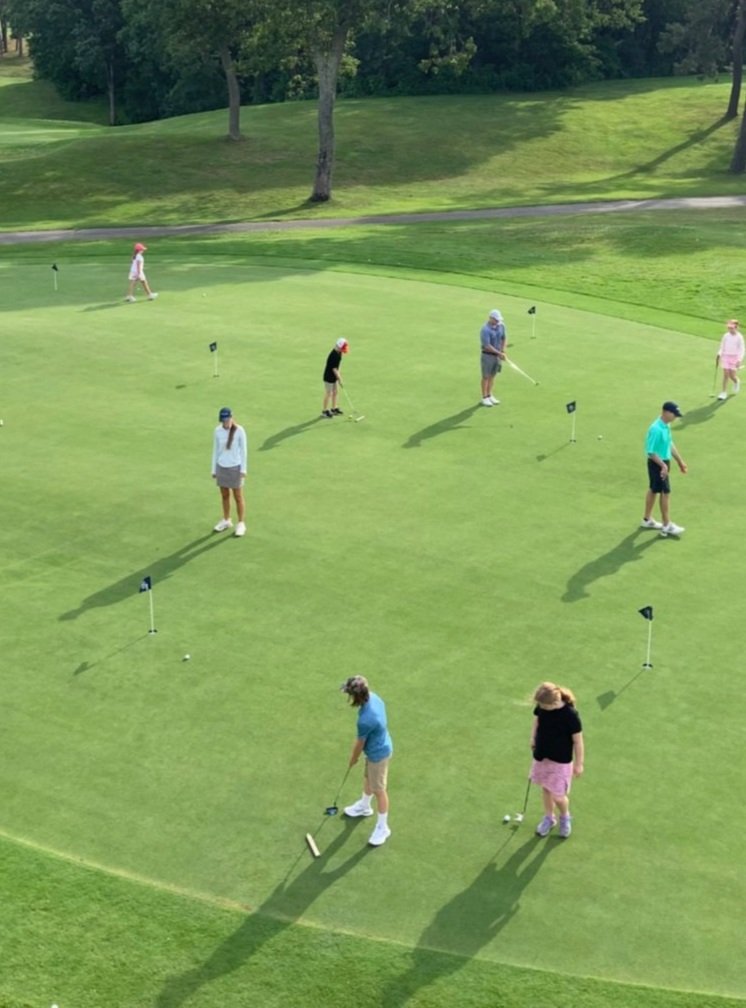 People practicing putting on a golf green