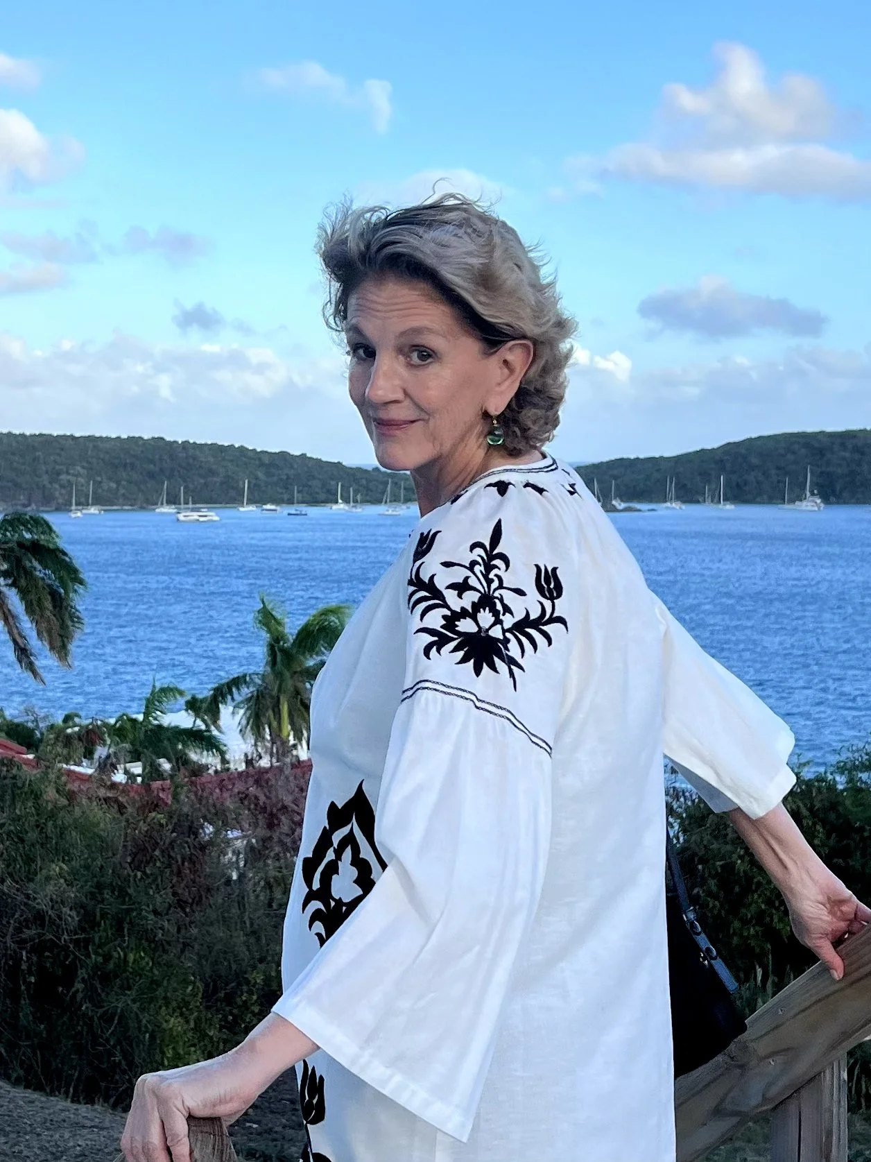 Founder Cathy OBrien standing near a bay with palm trees