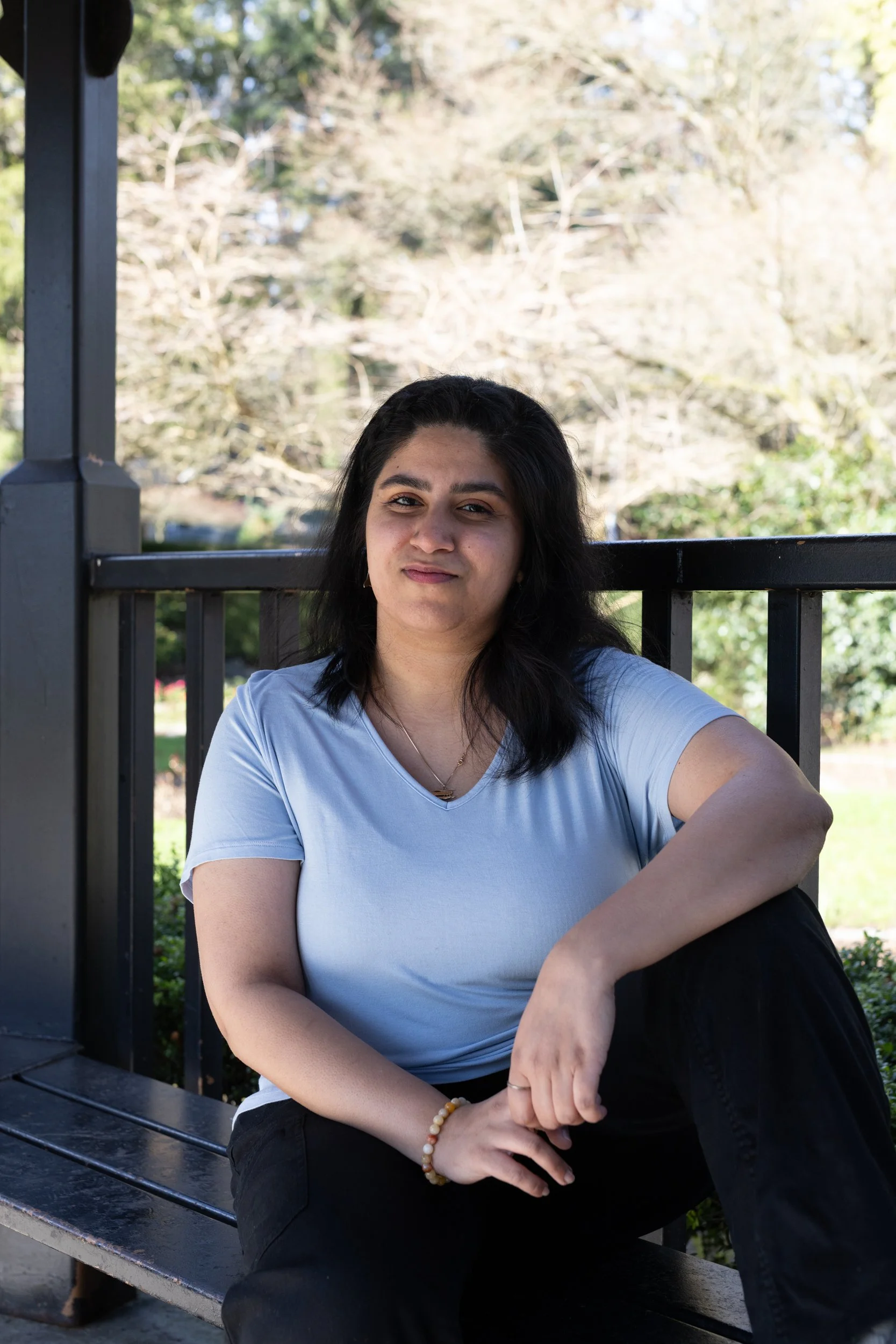 Woman looking at camera. She has black hair and a white tshirt