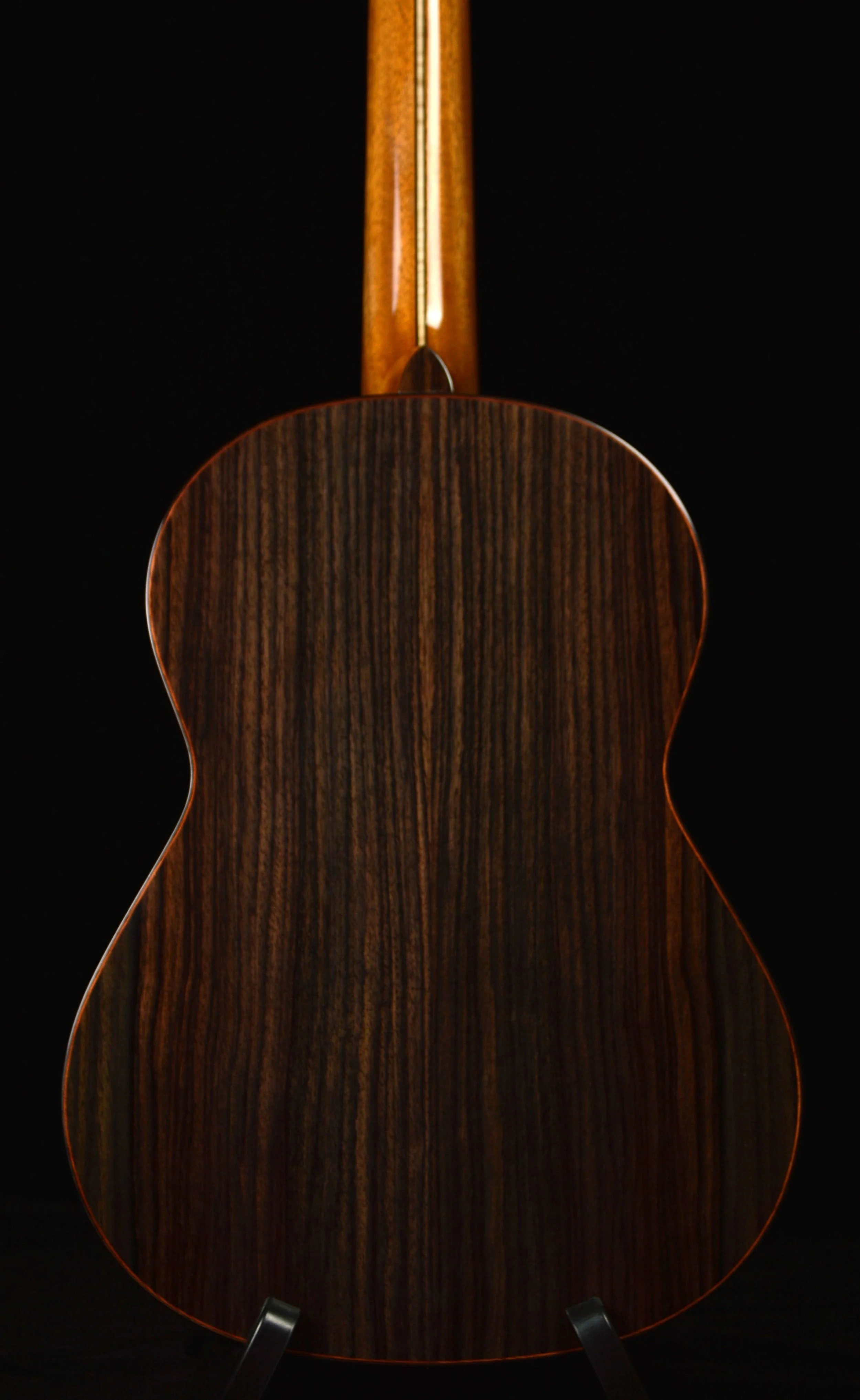 Close up of a Classical guitar with rosewood back and sides on black background