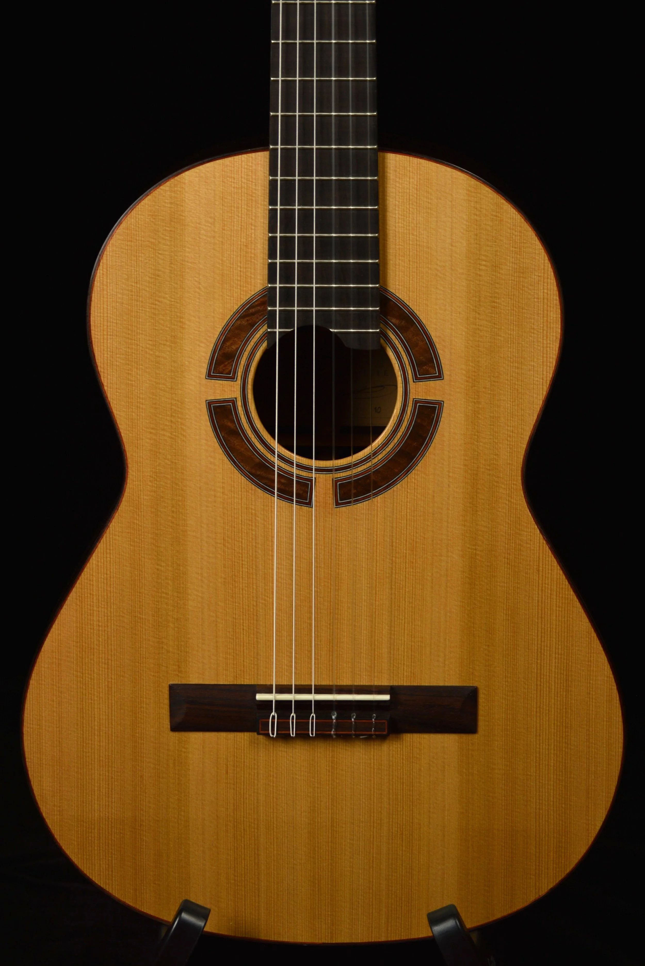 Close up of a Classical guitar with cedar top on black background
