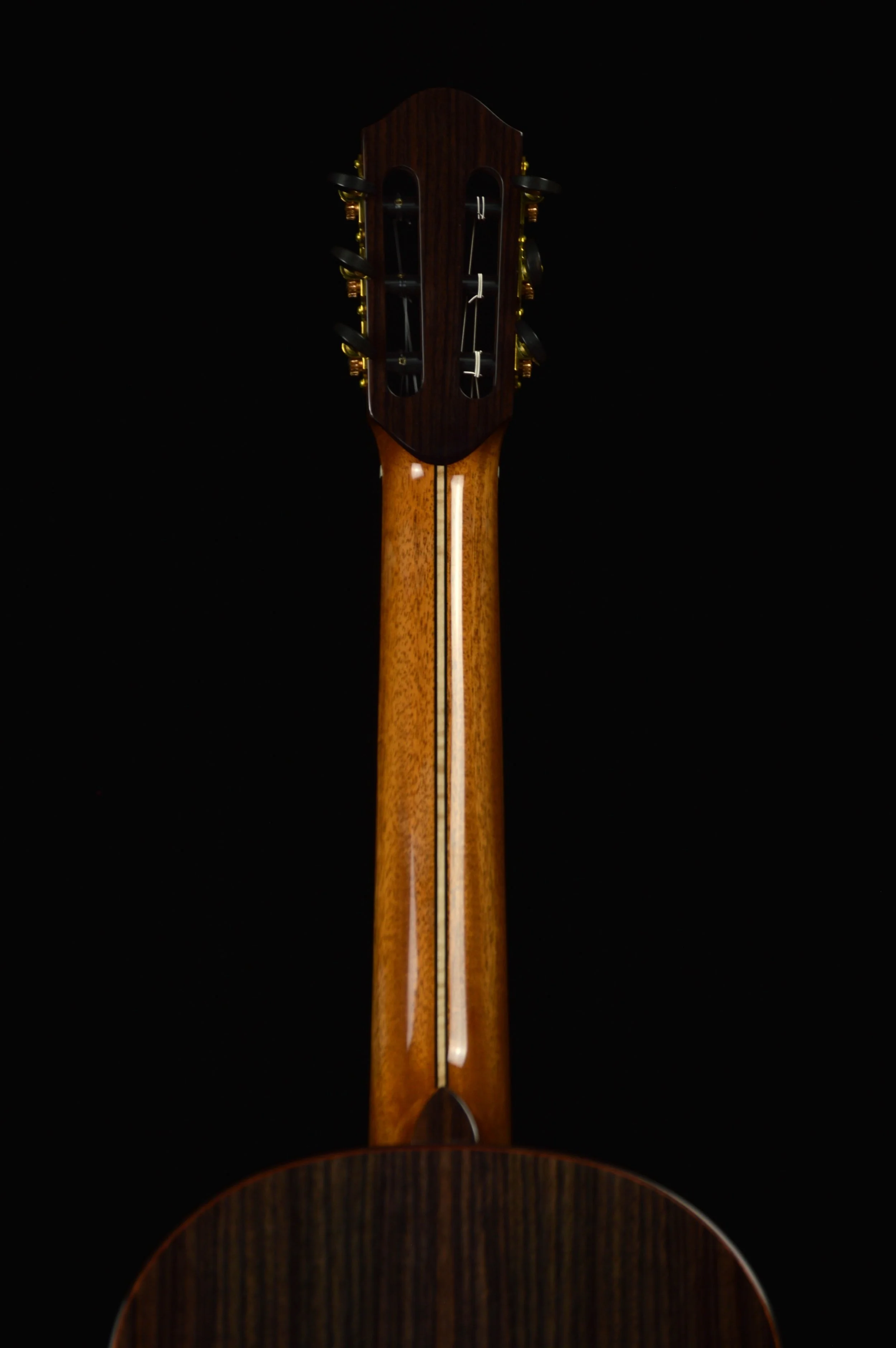 Close up of a Classical guitar with mahogany neck on black background