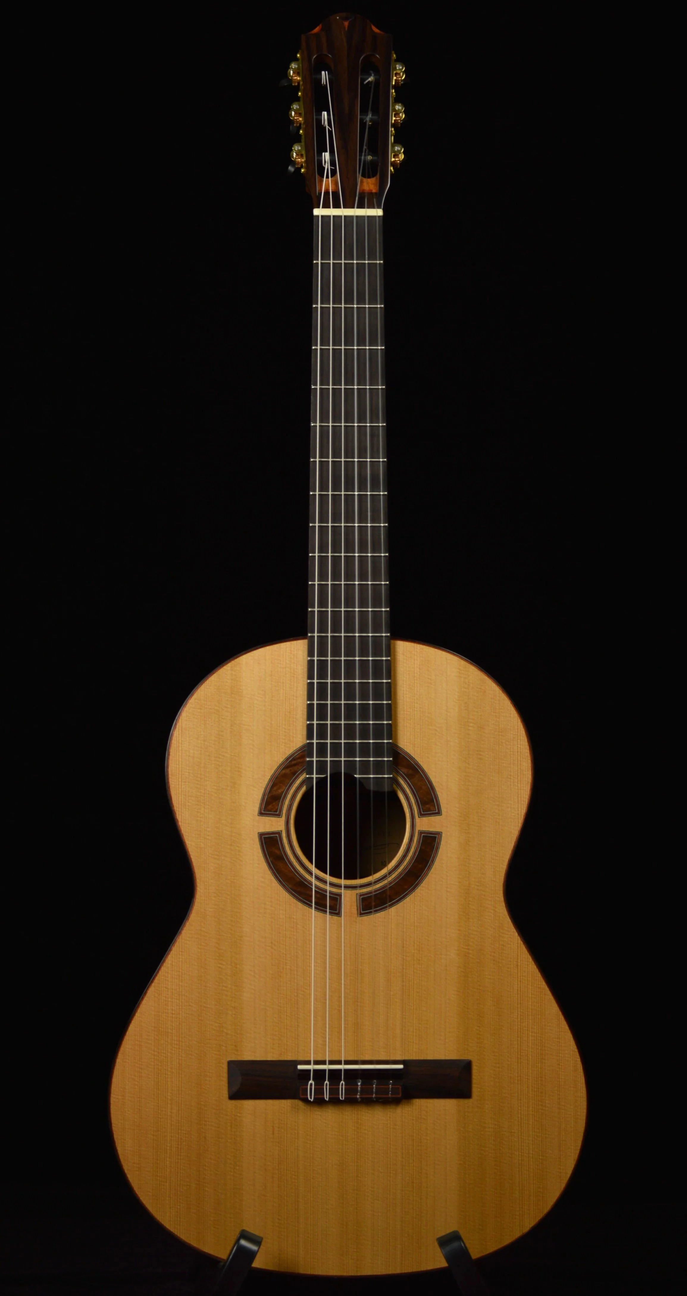 Classical guitar with cedar top on black background