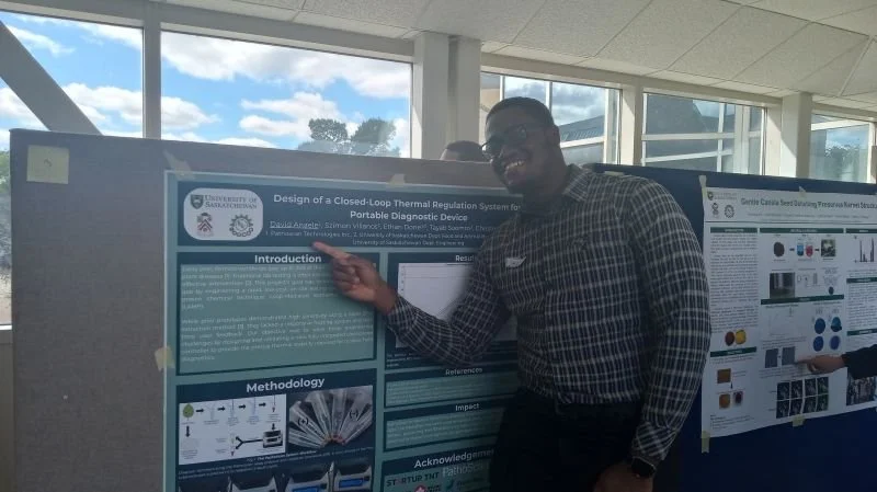 Man in checkered shirt presenting a scientific research poster at an indoor conference.