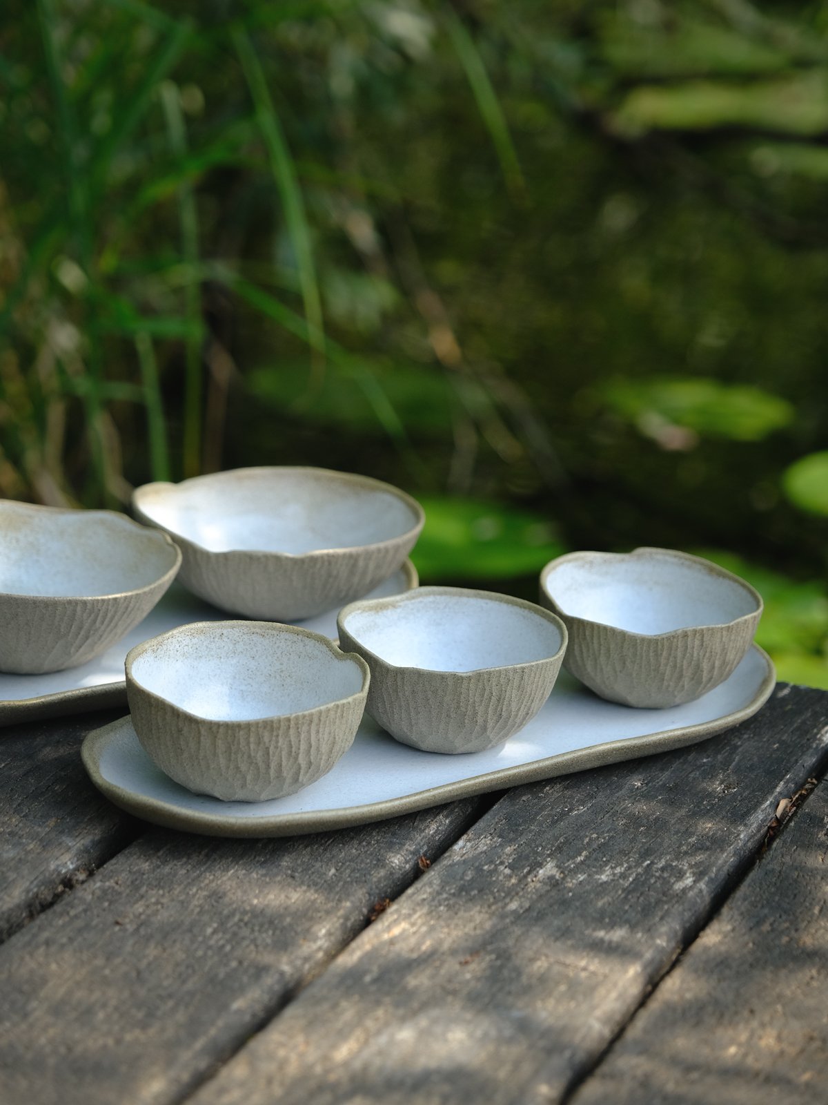 Two organic earthy tapas sets featuring an elongated plate and three matching bowls.