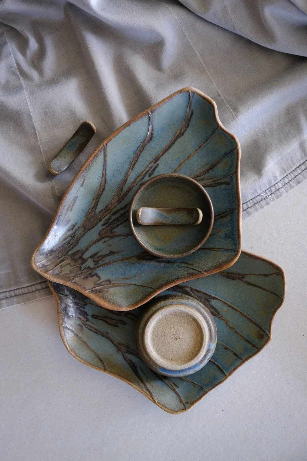 Wing-shaped patterned sushi trays, soy sauce bowls and chopstick rests displayed.